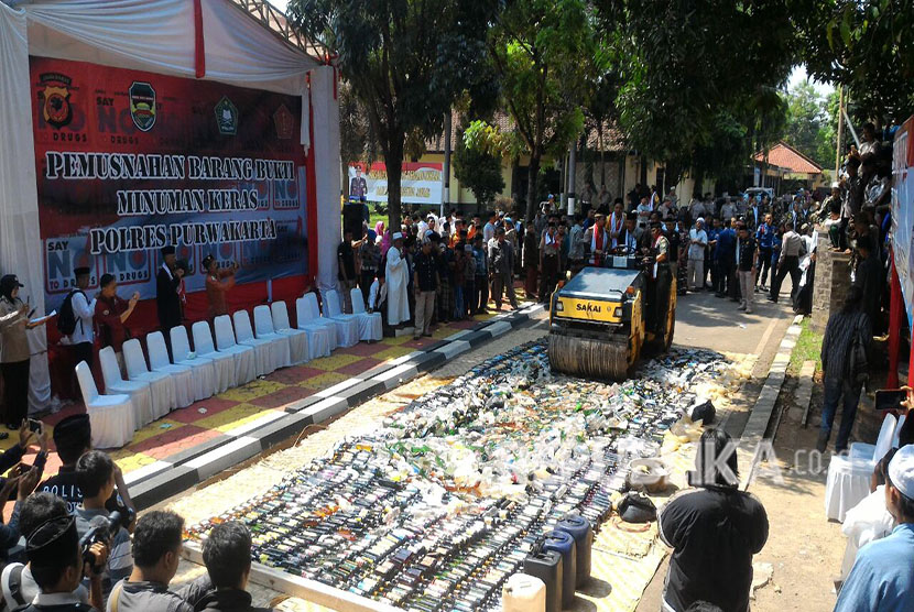 Kapolres Purwakarta AKBP Twedi Aditya Benyyahdi bersama unsur ulama, memusnahkan ribuan botol miras berbagai merek, tuak dan ciu, Sabtu (12/5).