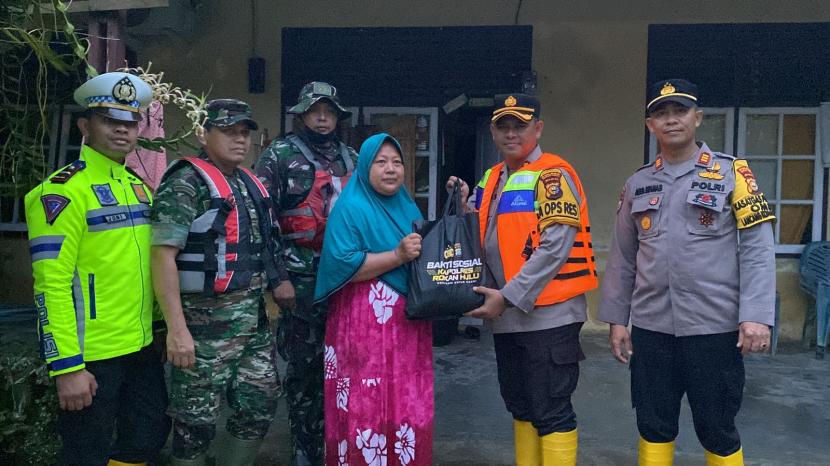 Kapolres Rokan Hulu AKBP Budi Setiyono memberikan bantuan sembako kepada korban banjir