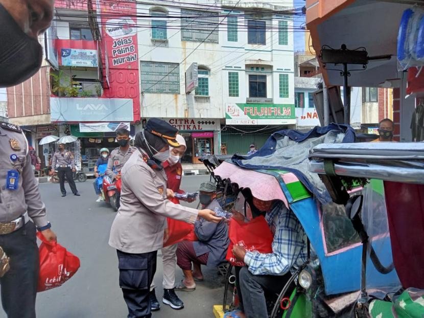 Kapolres Sukabumi Kota AKBP Sumarni membagikan paket sembako kepada warga penarik becak di Jalan Ciwangi, Kota Sukabumi, Jumat (25/6).