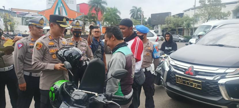 Kapolres Sumedang, AKBP Indra Setiawan, membagikan sembako dan helm kepada masyarakat saat kegiatan Operasi Zebra Lodaya 2022. 