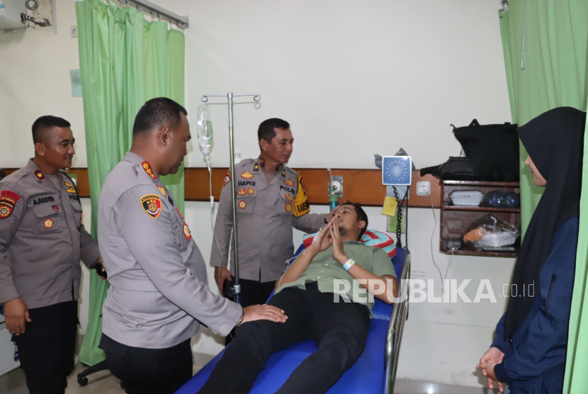 Kapolresta Bandar Lampung Kombes Pol Alfret Jacob Tilukay (kedua kiri) menjenguk anggota kepolisian yang terluka saat mengamankan aksi unjuk rasa petani singkong di depan Kantor Pemerintah Provinsi Lampung, pada Senin, 5 Mei 2025.