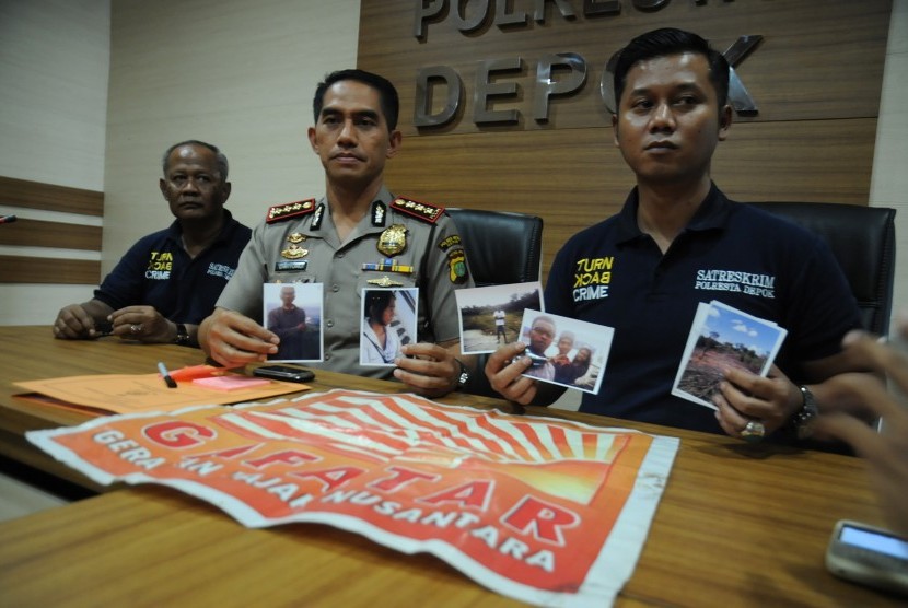 Kapolresta Depok Kombes Pol Dwiyono (tengah) bersama Kasat Reskrim Kompol Teguh Nugroho (kanan) menunjukkan foto satu keluarga yang hilang berikut atribut bendera Gerakan Fajar Nusantara (Gafatar) di Mapolresta Depok, Jawa Barat, Selasa (19/1).