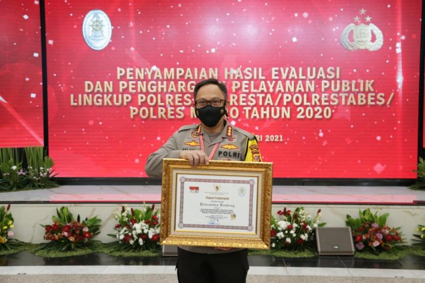 Kapolrestabes Bandung, Kombes Pol Ulung Sampurna Jaya sedang memegang piagam penghargaan dari Kemenpan RB terkait pelayanan publik yang prima.