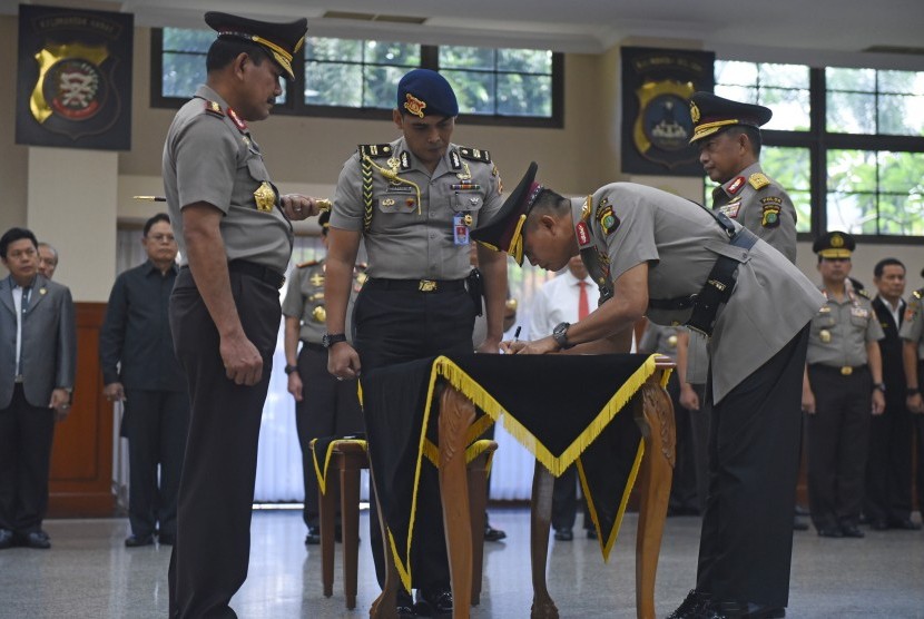 Kapolri Jenderal Pol Badrodin Haiti (kiri) menyaksikan penandatanganan berkas sertijab oleh Kapolda Metro Jaya Irjen Pol Moechgiyarto (kedua kanan) dan Kepala BNPT Irjen Pol Tito Karnavian (kanan) di Mabes Polri, Jakarta, Senin (21/3). (Antara/Hafidz Mubar