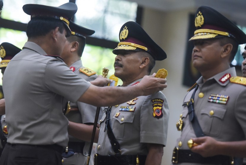 Kapolri Jenderal Pol Badrodin Haiti menyematkan tanda pangkat kepada Kapolda Jawa Barat Irjen Pol Jodie Rooseto (tengah) saat sertijab Perwira Tinggi Polri di Mabes Polri, Jakarta, Senin (21/3). 