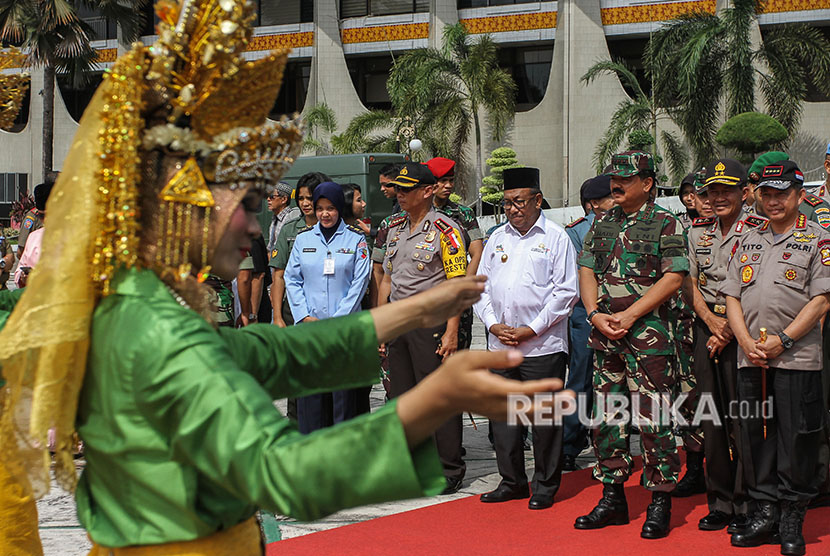 Kapolri Jenderal Pol. M Tito Karnavian (kanan) bersama Panglima TNI Marsekal TNI Hadi Tjahjanto (ketiga kanan), Kapolda Riau Irjen Pol Nandang (kedua kanan), dan Plt Gubernur Riau Wan Thamrin Hasyim (keempat kanan) disambut tarian setibanya di halaman Kantor Gubernur Riau, Pekanbaru, Riau, Jumat (20/4). 