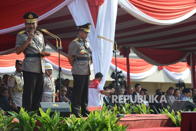 Kapolri Jenderal Pol Tito Karnavian (kanan) bersama mantan Kapolri Jenderal Pol Badrodin Haiti (kiri) memberikan kata sambutan saat mengikuti serah terima jabatan Kapolri di Lapangan PTIK, Jakarta, Kamis (14/7)