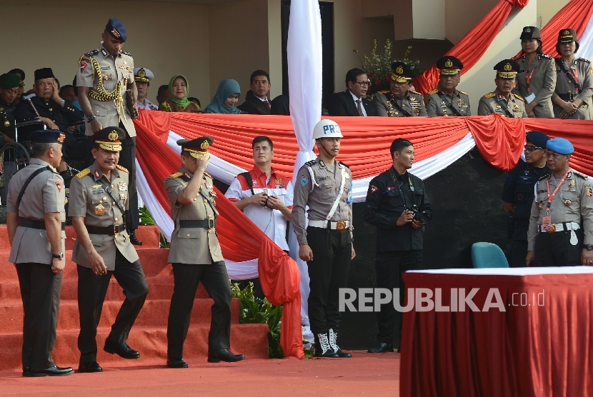 Kapolri Jenderal Pol Tito Karnavian (ketiga kiri) bersama mantan Kapolri Jenderal Pol Badrodin Haiti (kedua kiri) berjalan untuk menuju lapangan upacara untuk mengikuti serah terima jabatan Kapolri di Lapangan PTIK, Jakarta, Kamis (14/7).