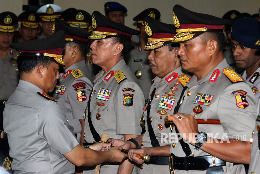 Kapolri Jenderal Pol Tito Karnavian (kiri) memberikan tongkat komando kepada Pejabat baru Kapolda Metro Jaya, Irjen Pol Idham Azis (kedua kanan) saat serah terima jabatan Kapolda Metro Jaya di Mabes Polri, Jakarta, Rabu (26/7).