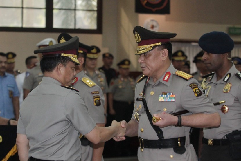 Kapolri Jenderal Pol Tito Karnavian (kiri) memberikan tongkat komando jabatan kepada pejabat baru Kapolda Sumatera Selatan (Sumsel) Irjen Pol Firli (tengah) saat Serah Terima Jabatan Pejabat Tinggi Polri dan Kapolda, di Rupatama Mabes Polri, Jakarta, Selasa (25/6/2019).