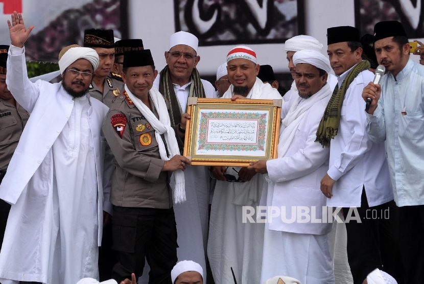 Kapolri Jenderal Pol Tito Karnavian menerima kaligrafi surat Al Maidah ayat 51 dari Habib Riziek Shihab saat Aksi 212 di kawasan silang Monas, Jakarta, Jumat (2/12)