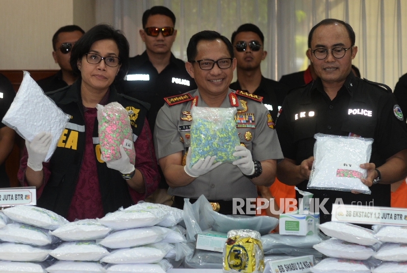  Kapolri Jenderal Pol Tito Karnavian (tengah), Menkeu Sri Mulyani (kiri), dan Direktur Tipidnarkoba Bareskrim Polri Brigjen Pol Eko Daniyanto (kedua kanan) menunjukkan barang bukti narkotik jenis ekstasi di Mabes Polri, Jakarta, Selasa (1/8).