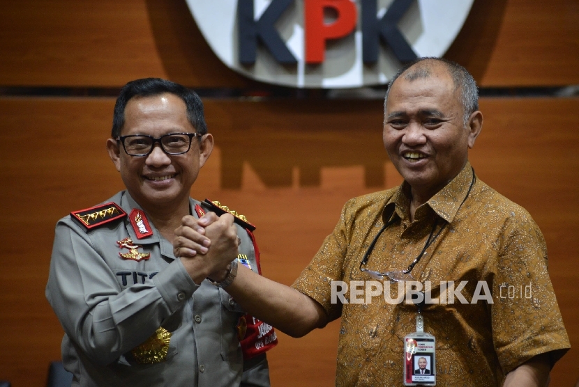 Kapolri Jenderal Tito Karnavian (kiri) bersalaman dengan Ketua KPK Agus Rahardjo (kanan) seusai memberikan keterangan kepada awak media saat mengunjungi pimpinan KPK di Gedung Merah Putih KPK, Jakarta, Senin (19/6).