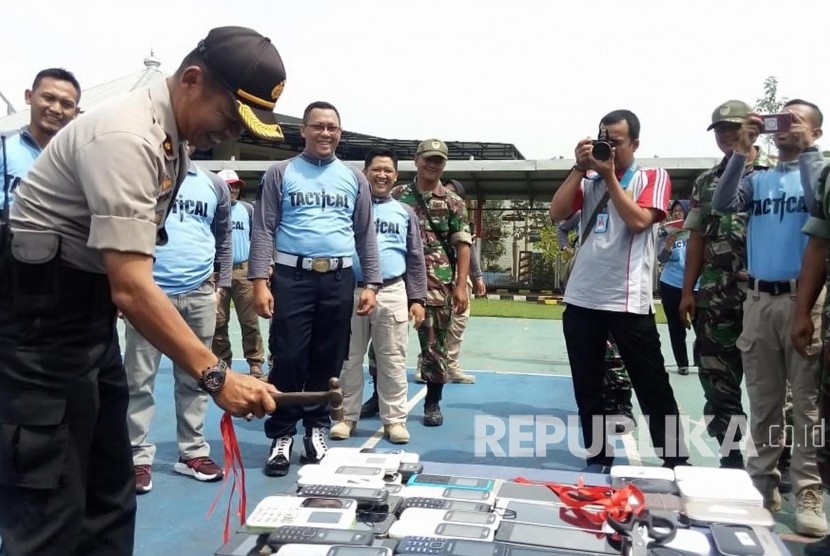 Kapolsek Baleendah, Kompol Priyono memusnahkan ponsel milik warga binaan Lapas Jelekong dengan menggunakan palu, Jumat (1/3).