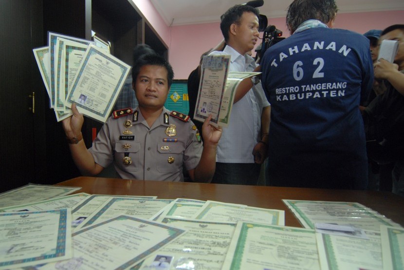  Kapolsek Pd Aren Kompol Hafidz Herlambang menunjukan barang bukti sejumlah ijazah palsu dan juga seorang pelaku Santoso alias Santosa saat gelar perkara di Mapolsek pd Aren, Tangerang Selatan, Selasa (26/3). 