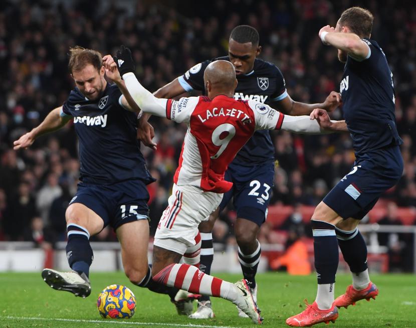 Kapten Arsenal Alexandre Lacazette berjibaku melawan para pemain West Ham United pada laga lanjutan Liga Primer Inggirs, Kamis (16/12).