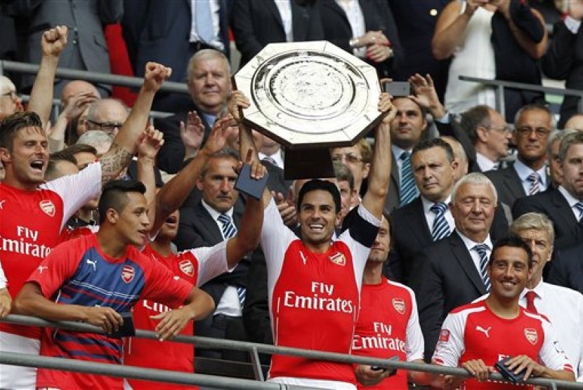 Kapten Arsenal, Mikel Arteta (tengah) mengangkat trofi Community Shield.