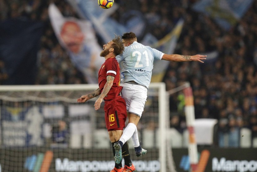 Kapten AS Roma, Danielle De Rossi berebut bola di udara dengan gelandang Lazio, Sergej Milinkovic-Savic pada laga Serie A di Olimpico, Ahad (19/11) dini hari WIB. Roma menang 2-1.