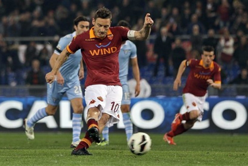 Kapten AS Roma, Francesco Totti, saat menjebol gawang Lazio lewat titik putih di laga Derby della Capitale di Stadion Olimpico, Roma, Selasa (9/4) dini hari WIB.