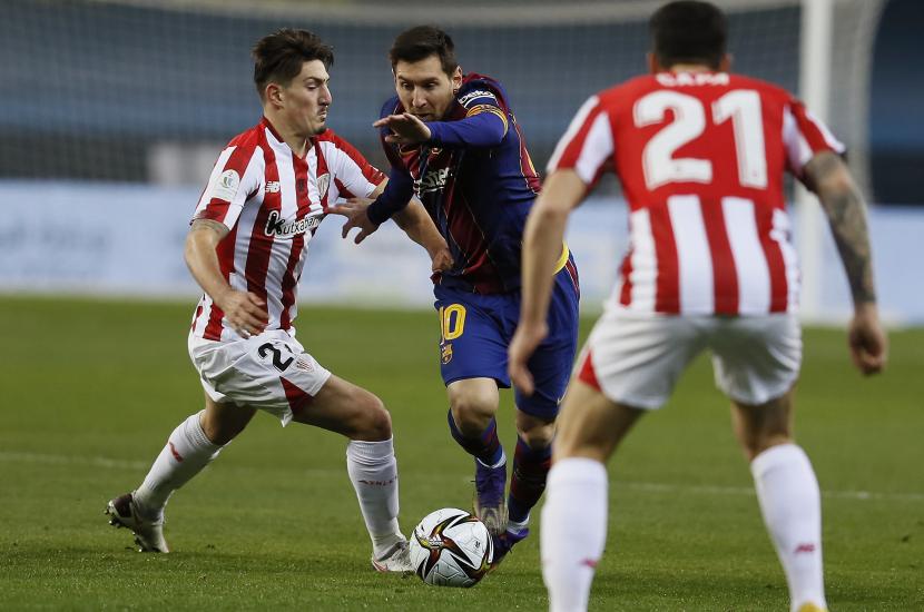 Kapten Barcelona Lionel Messi mencoba melewati pemain Atletic Bilbao dalam pertandingan Final Piala Super Spanyol, Senin (18/1).