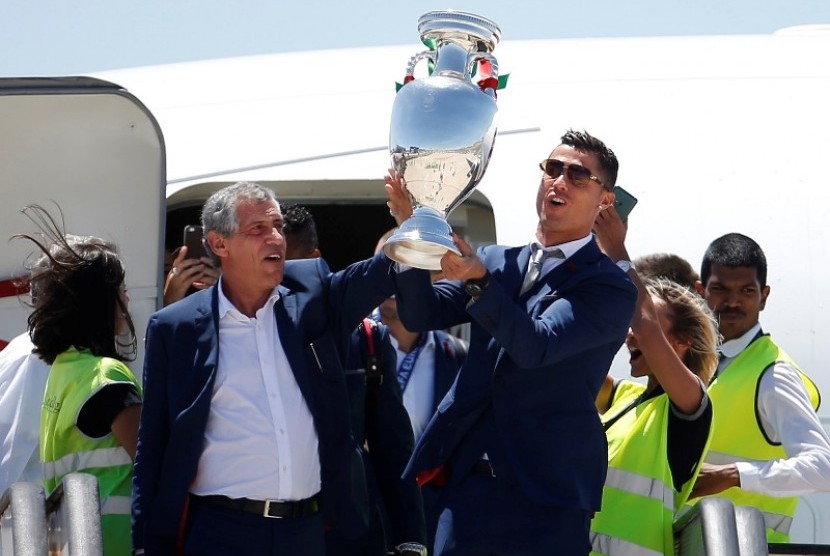 Kapten Cristiano Ronaldo dan pelatih timnas Portugal Fernando Santos memegang trofi Piala Eropa 2016 saat keluar dari pesawat.
