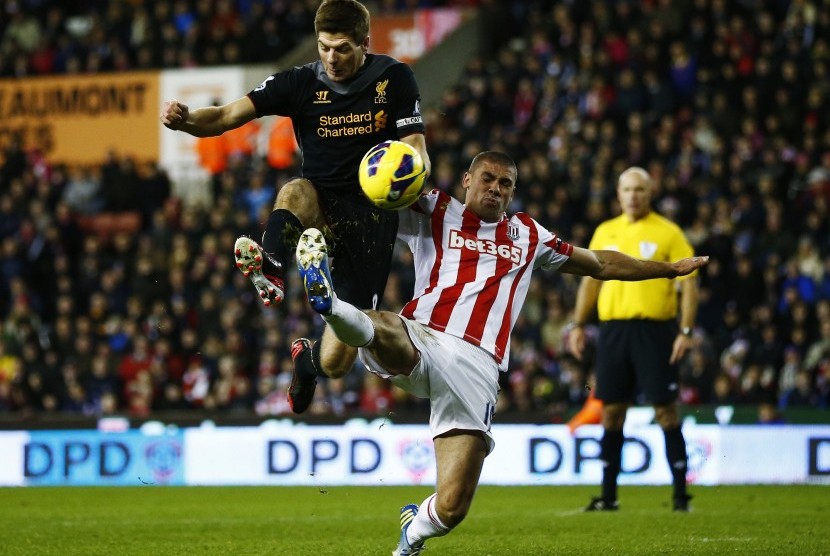 Kapten Liverpool, Steven Gerrard, berebut bola dengan striker Stoke City, Jonathan Walters, pada partai lanjutan Liga Primer Inggris.