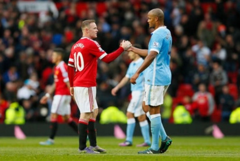 Kapten Manchester United Wayne Rooney (kiri) bersalaman dengan kapten Manchester City Vincent Kompany