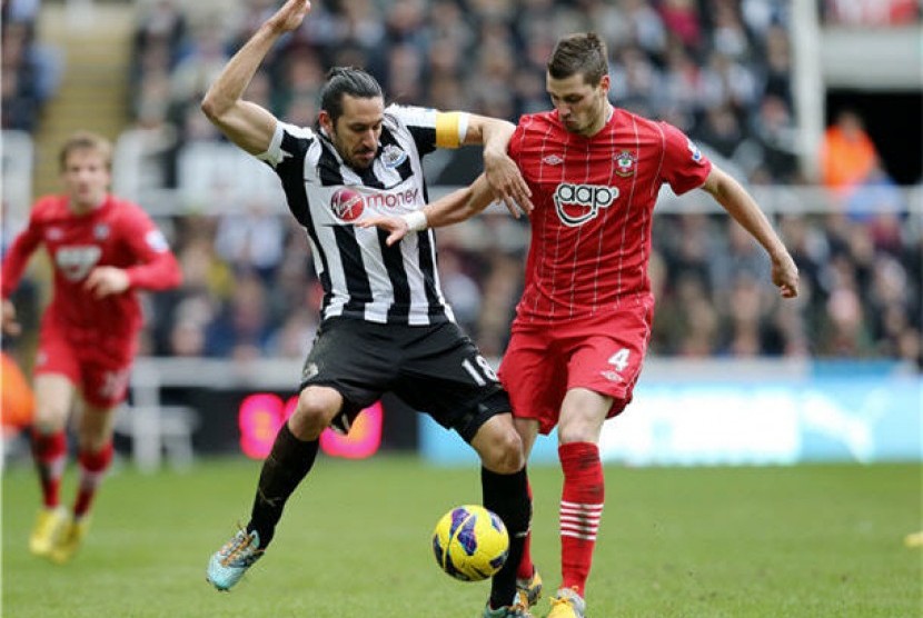 Kapten Newcastle United, Jonas Gutierrez (kiri), bertarung dengan gelandang Southampton, Morgan Schneiderlin (kanan), di laga Liga Primer Inggris di St James' Park, Newcastle, Ahad (24/2). 