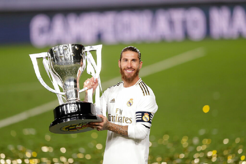 Kapten Real Madrid Sergio Ramos memegang piala setelah berhasil meraih gelar juara La Liga 2019-2020, Jumat (17/7) dini hari WIB.