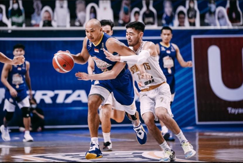 Kapten Satria Muda Pertamina Arki Dikania Wisnu membawa bola dijaga oleh point guard West Bandits Solo Widyanta Putra Teja di semifinal IBL 2021.