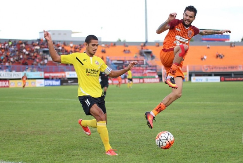 Kapten Semen Padang Hengki Ardiles (kiri) berebut bola dengan gelandang Pusamania Borneo FC Diego Michiels.