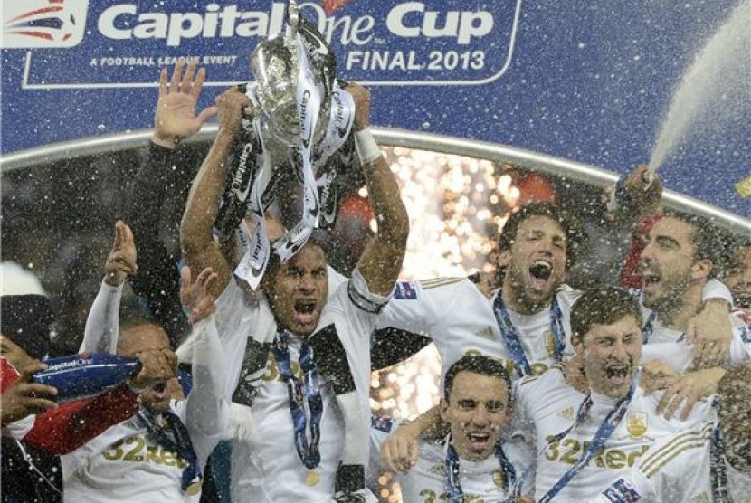 Kapten Swansea City, Ashley Williams (dua kiri), memegang trofi bersama rekan setimnya usai mengalahkan Bradford City 5-0 di final Piala Liga di Stadion Wembley, London, Ahad (24/2). 