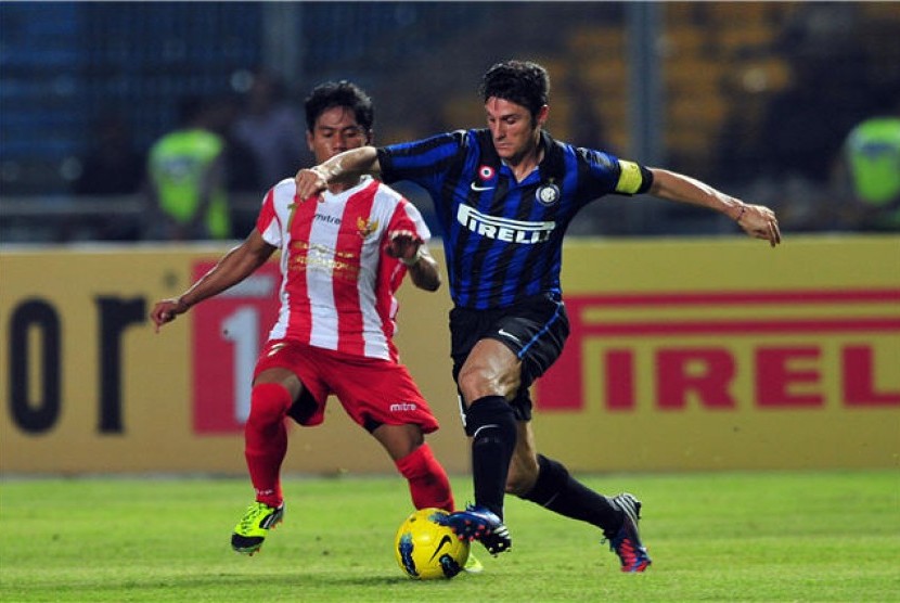 Kapten tim Inter Milan, Javier Zanetti (kanan), berusaha melewati hadangan pemain Indonesia Selection, GM Siregar, dalam laga persahabatan di Stadion Gelora Bung Karno, Senayan, Jakarta, Kamis (24/5). 