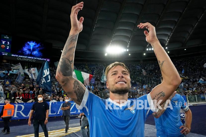  Kapten tim Lazio Ciro Immobile memberi isyarat kepada para pendukung yang merayakan di akhir pertandingan sepak bola Serie A antara Lazio dan Roma, di Stadion Olimpiade Roma,Ahad (26/9).