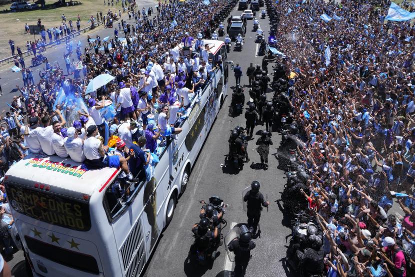 Kapten tim Lionel Messi, kiri, melihat ke belakang saat parade mudik tim sepak bola Argentina yang menjuarai Piala Dunia di Buenos Aires, Argentina, Selasa, 20 Desember 2022. 
