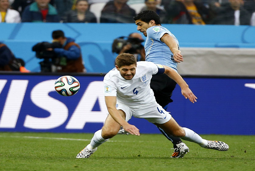 Kapten Timnas Inggris, Steven Gerrard (depan), berebut bola dengan striker Uruguay, Luis Suarez, di laga Grup D Piala Dunia 2014 di Stadion Corinthians, Sao Paulo, Kamis (19/6). 