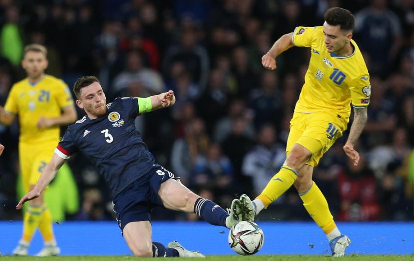 Kapten timnas Skotlandia Andy Robertson melancarkan tekel dalam laga playoff Piala Dunia 2022 melawan Ukraina.