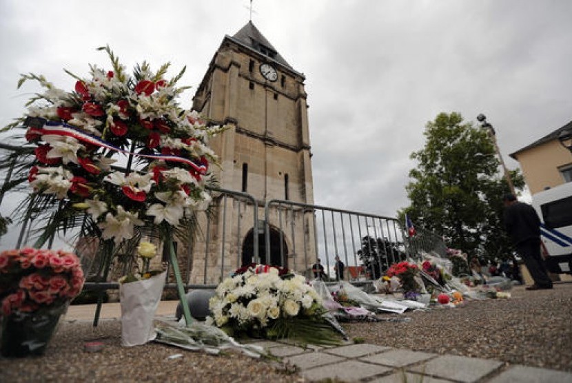 Karangan bunga dari Asosiasi Muslim Prancis diletakkan di samping gereja dimana serangan pisau menewaskan seorang pendeta di Saint-Etienne-du-Rouvray, Normandy, Prancis, Rabu, 27 Juli 2016.
