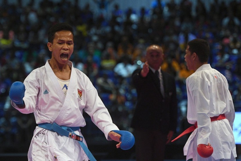 Karateka putra Indonesia Iwan Bidu Sirait (kiri) berteriak usai mendapatkan poin saat melawan karateka putra Filipina John Paul Bejar dalam perebutan medali emas karate nomor kumite -55 Kg putra SEA Games XXIX Kuala Lumpur di KLCC, Kuala Lumpur, Malaysia, Rabu (23/8). 