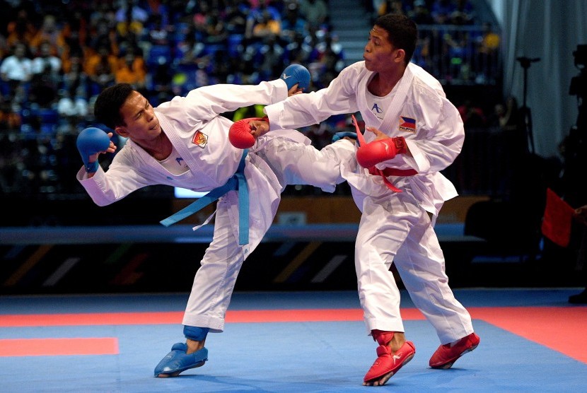 Karateka putra Indonesia Iwan Bidu Sirait (kiri) melepaskan tendangan saat melawan karateka putra Filipina John Paul Bejar dalam perebutan medali emas karate nomor kumite -55 Kg putra SEA Games XXIX Kuala Lumpur di KLCC, Kuala Lumpur, Malaysia, Rabu (23/8). 
