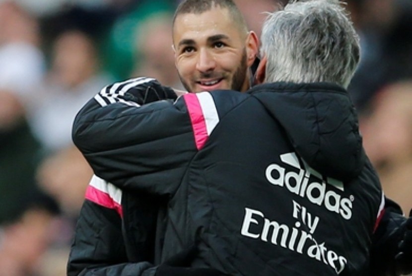 Striker Real Madrid Karim Benzema dipeluk oleh pelatihnya, Carlo Ancelotti (kanan).