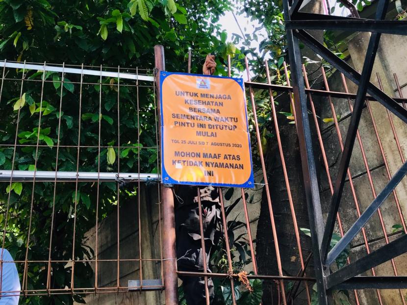Karyawan Apartemen Taman Rasuna memasang pengumuman penutupan akses jalan kepada warga Kelurahan Menteng Atas pada Selasa (28/7)..