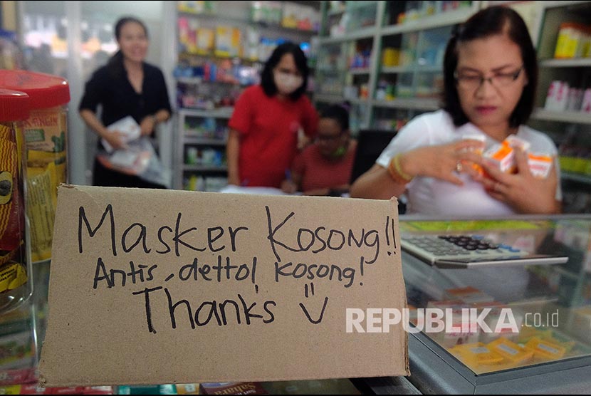 Karyawan apotek memajang tulisan pemberitahuan kehabisan stok masker dan produk cairan antiseptik di Denpasar, Bali, Selasa (3/3)