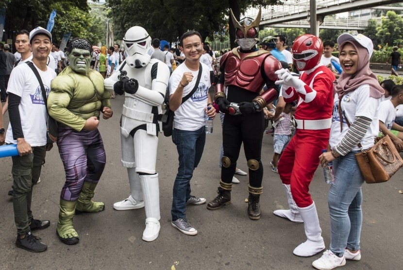 Karyawan bank BJB berfoto dengan tokoh komik saat Family Fun Walk HUT ke-56 bank BJB di Jakarta, Minggu (14/5). 