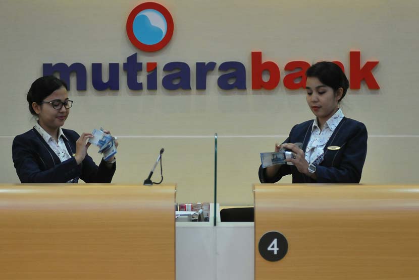 Karyawan Bank Mutiara menghitung uang nasabah, di Jakarta, Rabu (14/5).