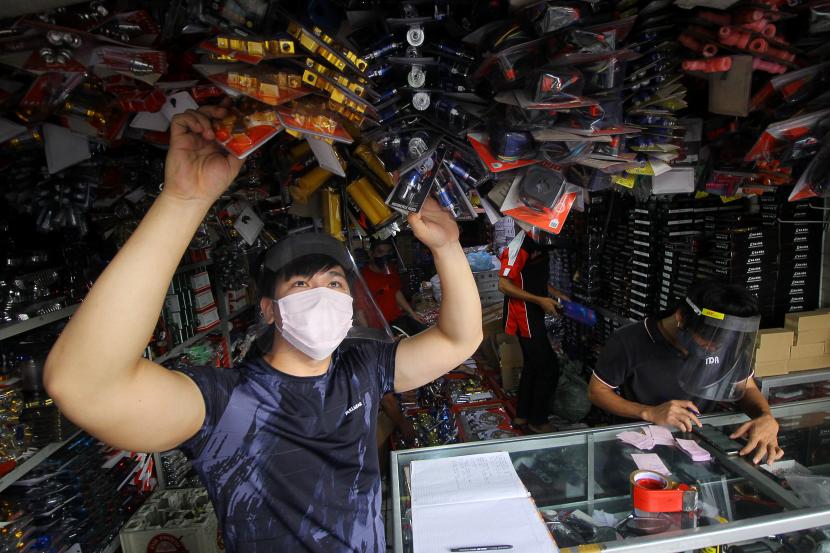 Karyawan beraktivitas menggunakan masker dan alat pelindung wajah (face shield) di salah satu toko di Jalan Kapasan, Surabaya, Jawa Timur, Jumat (17/4/2020). Penggunaan masker dan alat pelindung wajah bagi karyawan di tempat tersebut bertujuan untuk mencegah penyebaran COVID-19.