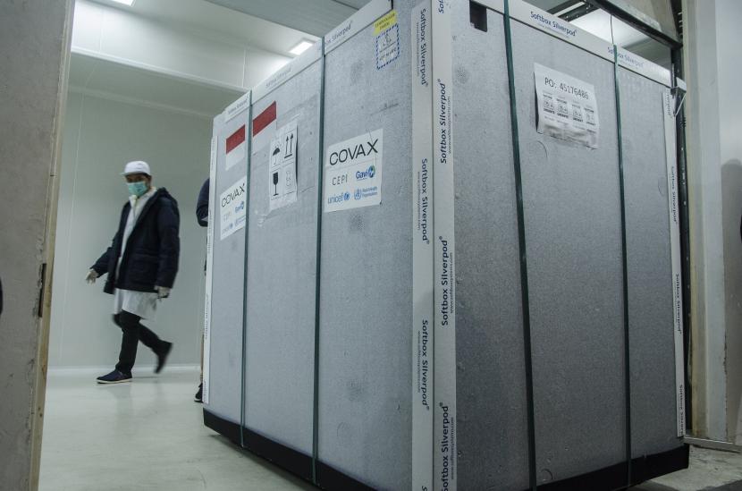 Karyawan berjalan di dekat kontainer berisi vaksin Covid-19 AstraZeneca saat tiba di Bio Farma, Bandung, Jawa Barat.