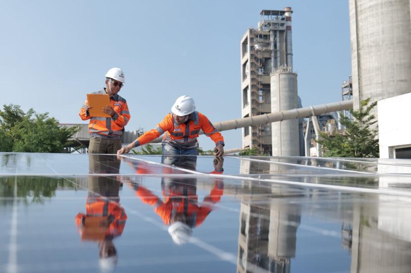  Karyawan melakukan pengecekan panel surya yang telah terpasang di atap gedung utama kantor PT Solusi Bangun Indonesia Tbk (SBI) Pabrik Tuban, Jawa Timur.