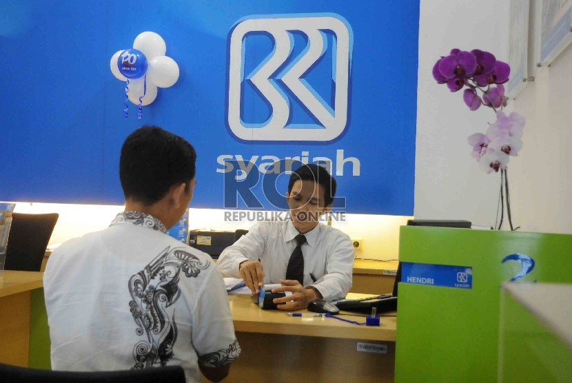 Karyawan melayani nasabah di Bank BRI Syariah, Jakarta, Kamis (17/12).