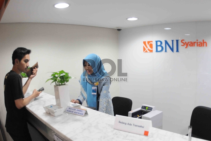 Karyawan melayani nasabah di banking hall Bank BNI Syariah, Jakarta, beberapa waktu lalu..